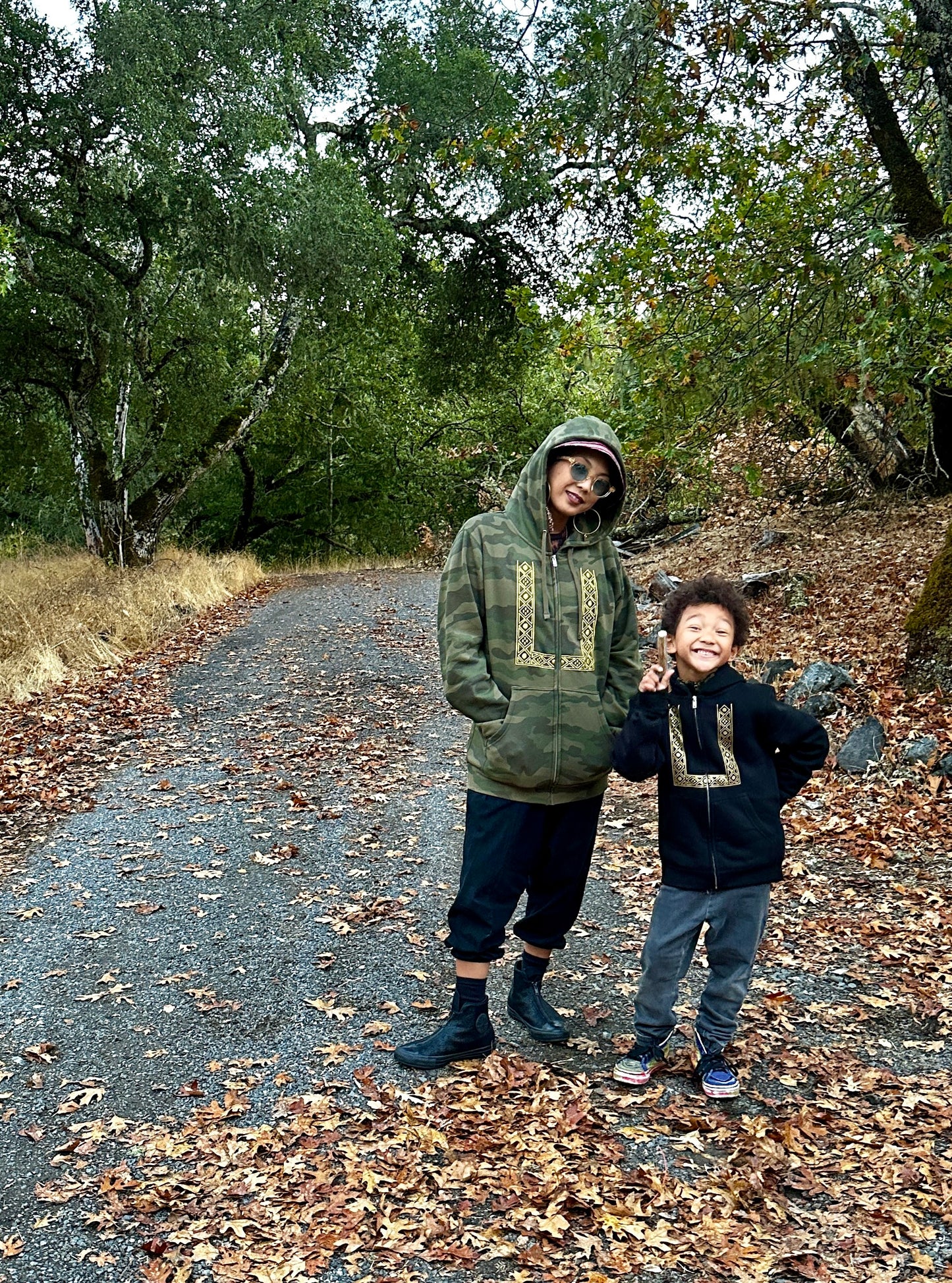 Mother and son wearing zip up barong hoodies hiking in the forest